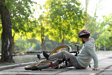 Sporty young man fallen off his bike in park