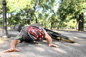 Young man fallen off his bike in park
