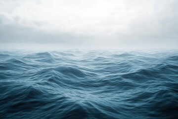 Obraz premium Calm ocean waves under a cloudy sky.