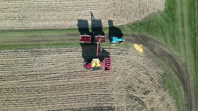 Top view by drone of an agricultural machine harvesting the last part of a cornfield. - Vue de dessus par drone d'une machine agricole r&eacute;coltant la derni&egrave;re partie d'un champ de ma&iuml;s