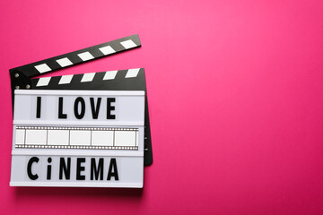 Light box with text on clapperboard on pink background, space for text