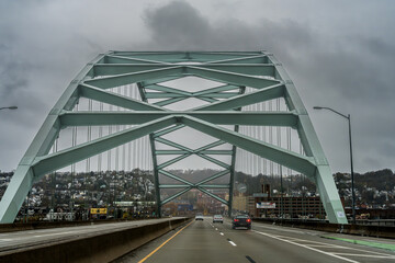 Obraz premium Crossing the Birmingham Bridge in Pittsburgh Pennsylvania on a rainy day.