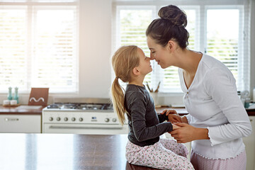 Happy mother, kid and touch nose for love, care or family connection with parent in home kitchen....