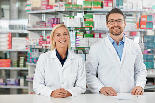 Portrait, man and woman in pharmacy with smile, healthcare and professional service in medicine store. Health insurance, drugs and pharmacist team in dispensary for medical advice, support and help