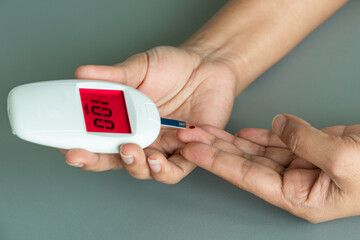 woman's hands checking diabetes and hyperglycemia with digital blood sugar meter. Healthcare and...