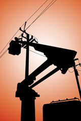 Silhouette of power lineman stand on bucket truck and closing a single phase transformer on energized high-voltage electric power lines.