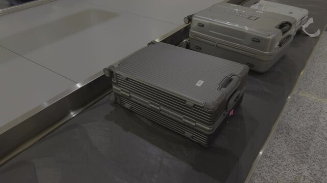 Close-up view of suitcases moving on an airport baggage carousel.