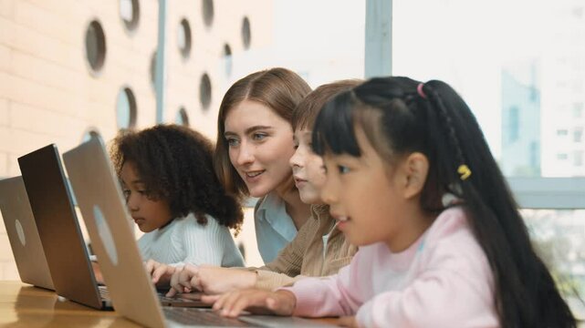 Smart teacher teaching and looking student using laptop at classroom. Professional instructor explained about programing engineering code or prompt while studying and learning program. Erudition.
