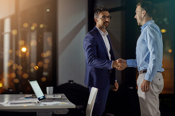 B2B, handshake and partnership with business men in office at night for thank you or welcome. Bokeh, deal and mockup with employee people shaking hands for team onboarding or recruitment on space