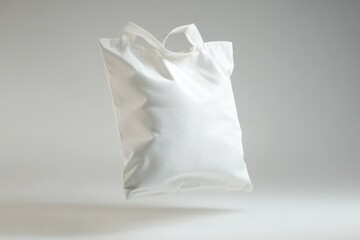 Blank white tote bag mockup, floating on a light gray background.