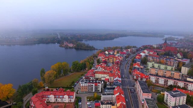 Aerial establishing overview of Elk, Poland along Wojska Polskiego Street on foggy day