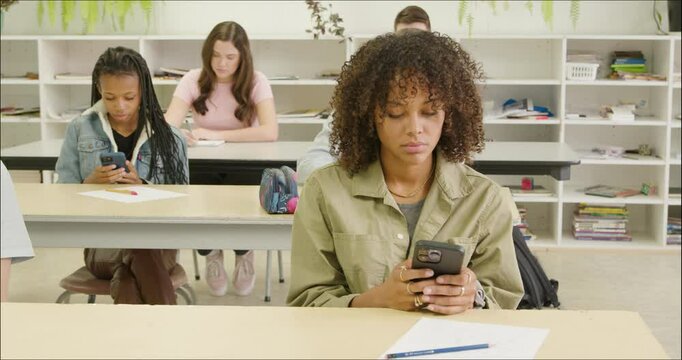 Girls Texting in Class. Students Distracted on Cell Phone Apps in High School - College Class Room. Girl Students Focused Smart Phone. Millenial, Gen Z, Gossip, Distraction, ADHD, Short Attention Span