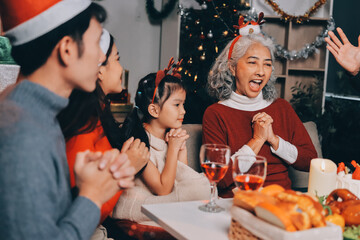 Happy multigeneration family enjoying in opening gifts on Christmas eve at home.