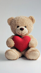 Obraz premium Teddy bear holding red heart against white background