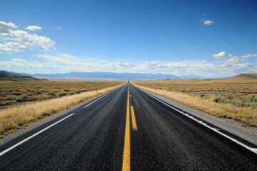 Obraz premium Vast highway disappearing into distant mountains.