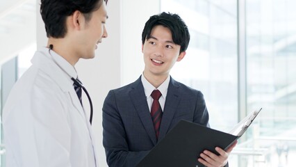 話をする医者と営業職の男性