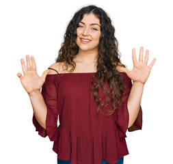 Young hispanic girl wearing casual clothes showing and pointing up with fingers number nine while...