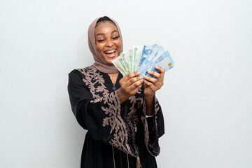excited and happy african muslim lady holding some money