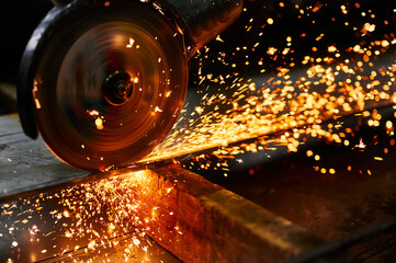 Metal plate cutting with abrasive disk and splashing sparks