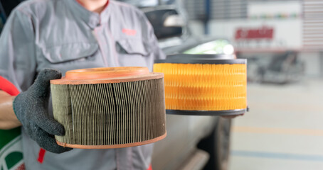 Mechanic in garage shows off new and old air filters