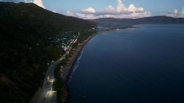 Picturesque aerial drone shot of tropical island village and rural road facing a vast cove at Cabugao, Bato, Catanduanes.