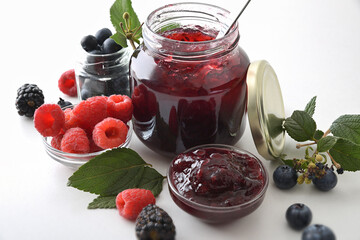 Jars with forest fruits jam and berries elevated view