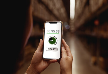 Close-up view of woman using smartphone with start button for timer, countdown timer application