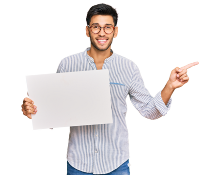 Young handsome man holding blank empty banner smiling happy pointing with hand and finger to the side