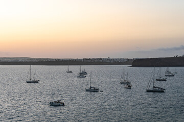 Boats anchored peacefully in the harbor during twilight hours in a coastal town