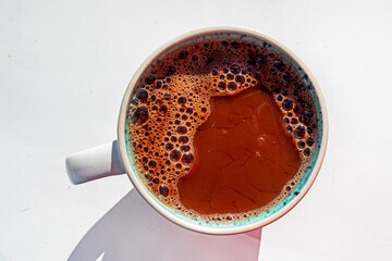 cup of hot chocolate stands on a white background. flatlay