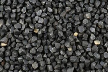 Seamless texture of dark gray and black gravel stones, perfect for backgrounds or design projects.  High-resolution image.