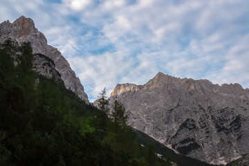 Hiking trail with scenic view of rugged majestic mountain peaks of Julian Alps seen from Krnica...