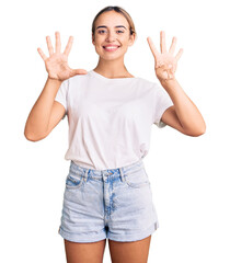 Young beautiful blonde woman wearing casual white tshirt showing and pointing up with fingers...