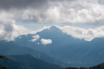 Mountain peak Storzic in Kamnik&ndash;Savinja Alps seen from Begunjscica, Loibl Pass, Karawanks, Slovenia Austria. Wanderlust in Slovenian Alps in summer. Valley covered with clouds. Peace and tranquility