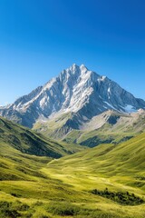 Obraz premium A mountain range with a snow covered peak and a clear blue sky