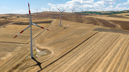 Aerial view of wind turbines among wheat fields.