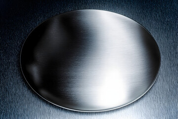 A polished, brushed metal plate with a smooth, silver texture