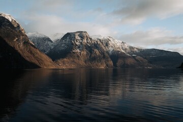 Obraz premium Snow-capped mountains reflecting on a fjord.