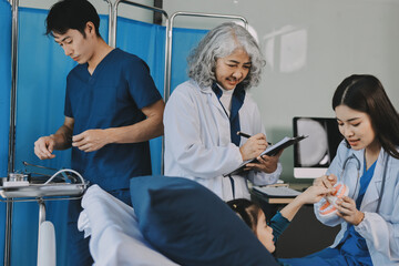 Obraz premium A team of doctors and nurses are working to treat a female patient in the patient's room.
