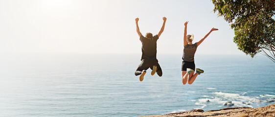 Ocean view, back and couple jump with celebration, fun and bonding for freedom and fitness. Blue...