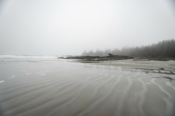 Chesterman beach all foggy on a moody, cloudy day. Near Tofino, Vancouver Island, British Columbia, Canada