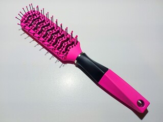 Pink hairbrush isolated on white background. A special item for styling hair. An item used in the...