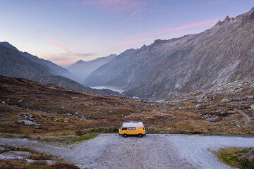 Vintage yellow camper van parked on Grimsel Pass in the Alps Mountains, Switzerland