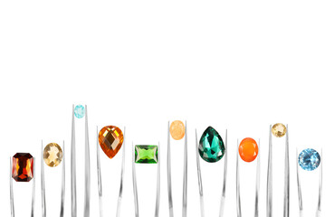 Tweezers with different shiny gemstones on white background, set