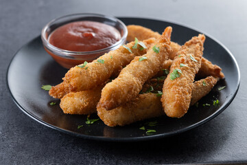 Breaded Torpedo shrimps on black slate background