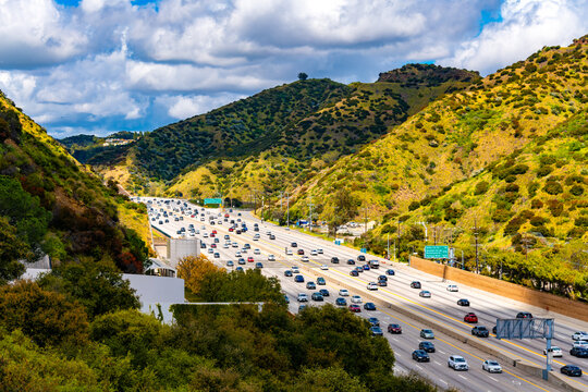 &ldquo;California Interstate 405&rdquo; or &lsquo;San Diego Freeway&rsquo; is a busy multi-lane highway in the metropolis of Los Angeles (USA). Numerous cars drive on a section of the road in the sunny hills of the city.