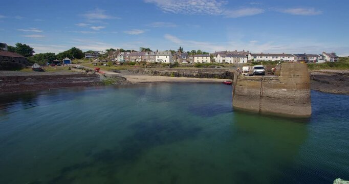 shot looking into the Craster harbour, with village in background