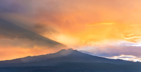 beautiful panorama of volcano mountain during evening synset with twilight clouds and shadows above majectic mountain and amazing cloudy sunset sky on background
