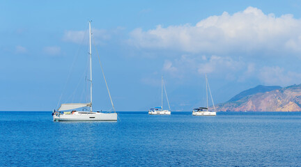 Obraz premium sailing yacht boats with white sails in blue sea , seascape of beautiful ships in sea gulf with mountain coast on background