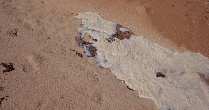 time lapse mid shot from right to left of frame of incoming high tide flowing over dry sand